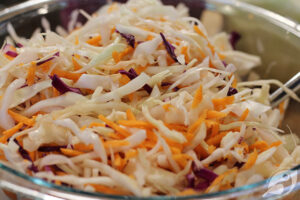 making Creamy Coleslaw green and purple cabbage with carrots