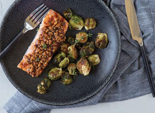 Maple Walnut Crusted Salmon on a plate with roasted Brussels Sprouts