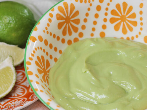 Dairy-Free Avocado Cream closeup with limes in the background
