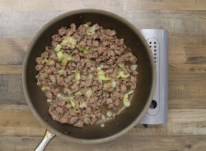 sausage, onion and celery frying in a skillet