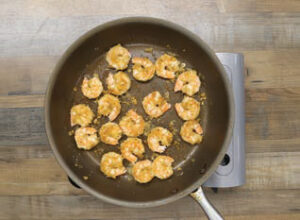 frying the coated shrimp in grapeseed oil in a skillet on the stovetop