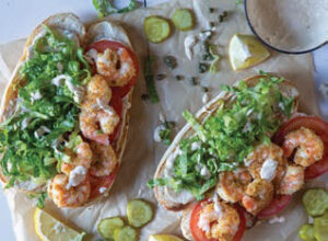layering the lettuce, tomato and shrimp onto the baguettes
