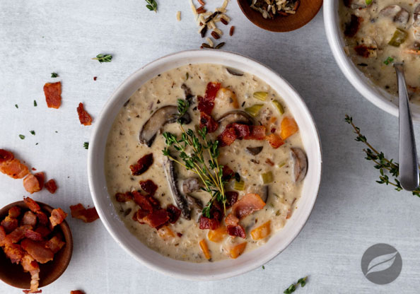 Creamy Mushroom & Wild Rice Soup served in a bowl with bacon and thyme