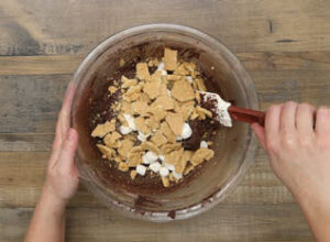 Fold in the mini marshmallows and graham crackers (setting aside a few pieces of graham cracker and a few mini marshmallows for garnish)