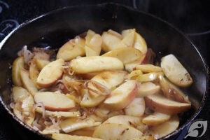 apples and shallots cooking in a cast iron skillet