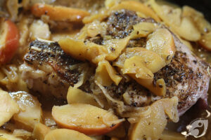 cooked apples and shallots with a pork chop in the skillet