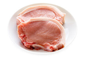 raw pork chops on a plate