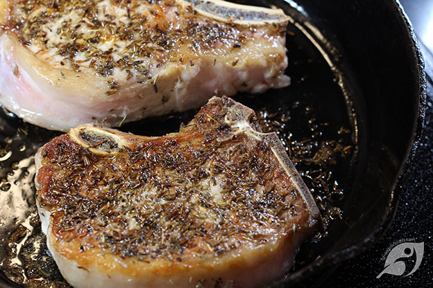 seared pork chops in a cast iron skillet