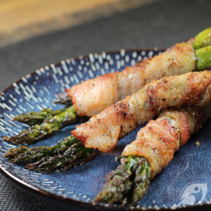 Grilled Bacon Wrapped Asparagus bundles on a blue plate.