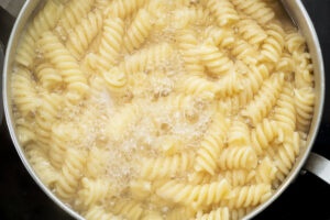 Fusilli pasta cooking to al-dente’. Generally, you’ll bring a large pot of water to a boil. Add salt and pasta. Most pasta will cook in 8 to 12 minutes until it is tender and firm but no longer crunchy - al-dente’ (Ahl-DEN-Tay).