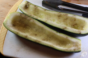 Oil, salt and pepper on zucchini halves