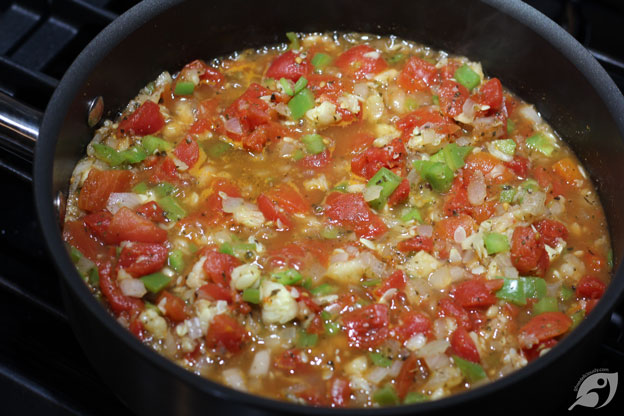 Mixed vegetables and tomatoes in the skillet to simmer