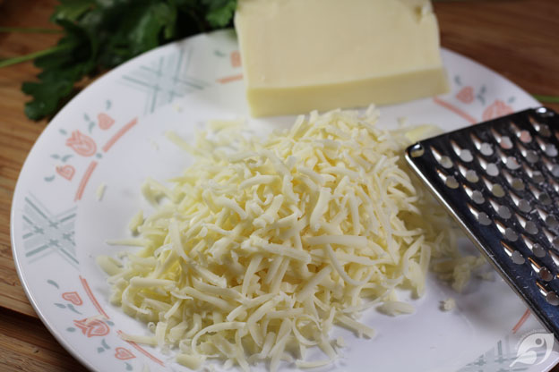 Grating the mozzarella cheese onto a plate