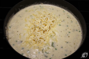 Add the shredded cheese, tarragon, pepper, and salt. Continue to stir lightly over medium-low heat until the mixture thickens.