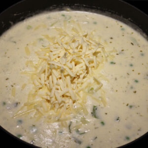 Add the shredded cheese, tarragon, pepper, and salt. Continue to stir lightly over medium-low heat until the mixture thickens.