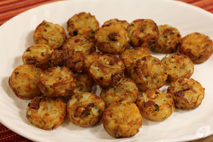 When the cups are filled, bake for 12-15 minutes until the potatoes are golden browned around the edges. Remove from the oven, spray the top with more cooking spray, then turn each tot over using a spoon or table knife. Coat the tot tops again with cooking spray and return to the oven to continue baking for 12-15 minutes until golden browned.