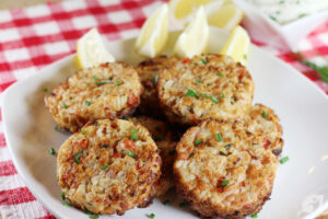 5. Transfer the crab cakes to plates or a serving platter. Sprinkle with fresh chopped chives and serve with lemon wedges and dill sauce.