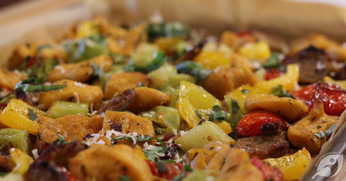 Closeup of roasted gnocchi, sausage and veggies on a sheet pan.