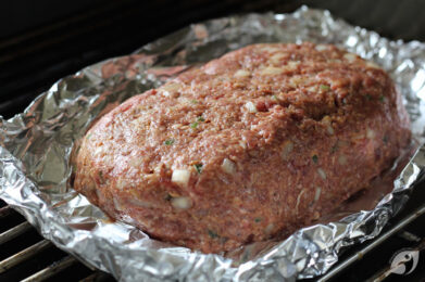 Put the meatloaf with the foil placed on unoiled grates over the unlit side of the grill.