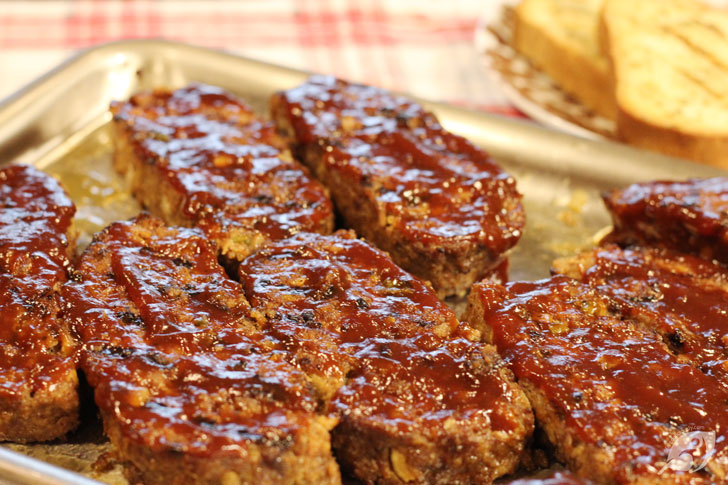 Increase the grill heat to high (450° to 500°F) and oil the grates. Cut the cooled meatloaf crosswise into even thick slices (about 1-inch thick). Place the pieces on the oiled grill grates and sear both sides of the exterior uncovered until grill marks appear for about 3-4 minutes per side. Brush each slice on top with the remaining ½ cup of barbecue sauce and continue to grill for about 1 minute until the sauce becomes slightly caramelized.