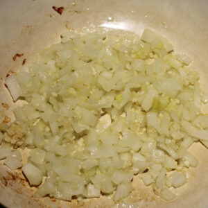 Heat the grapeseed oil over medium heat in a heavy-bottom pot or Dutch Oven. Sauté the chopped onion for 4-5 minutes to soften and become translucent, then add the minced garlic and ginger, continuing to cook for about two minutes until everything becomes fragrant.