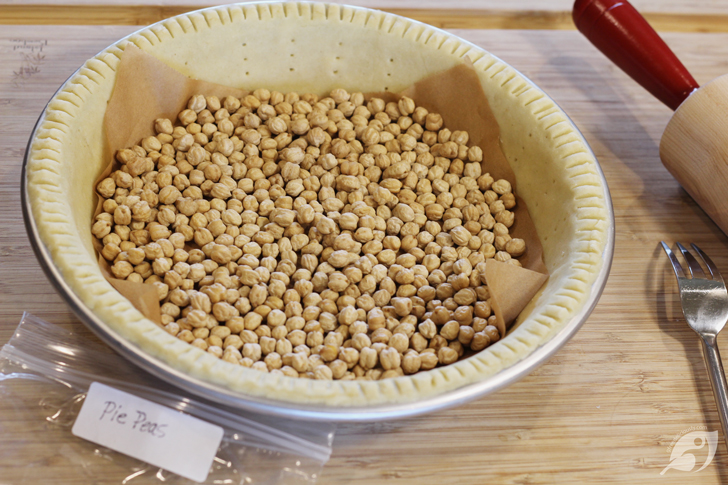 To pre-bake for a custard-filled pie, top the pie dough with foil or parchment paper and fill with pie weights or dried beans. Preheat the oven to 375°F and bake for 25 minutes. Remove the pie weights to use again, discarding the foil or parchment paper. Then continue baking for 10 to 15 minutes more until the crust looks light golden brown.