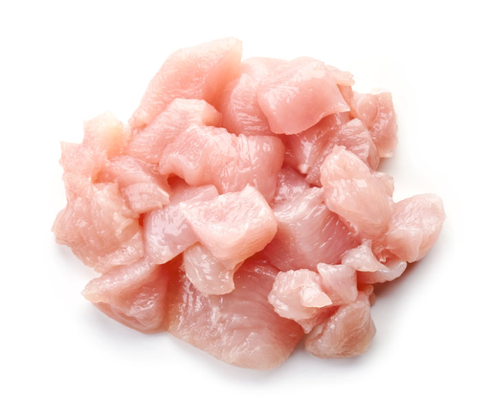 Heap of raw cut chicken fillet isolated on white background, top view