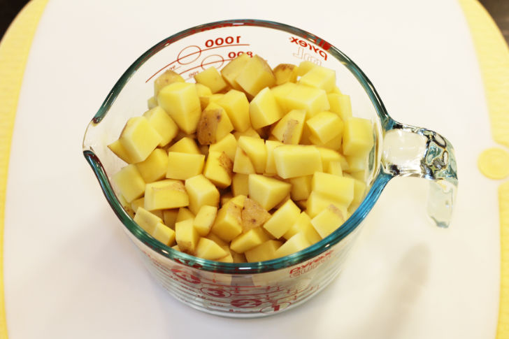 A four cup meaturing cup with 1/2 inch cubes of potatoes.