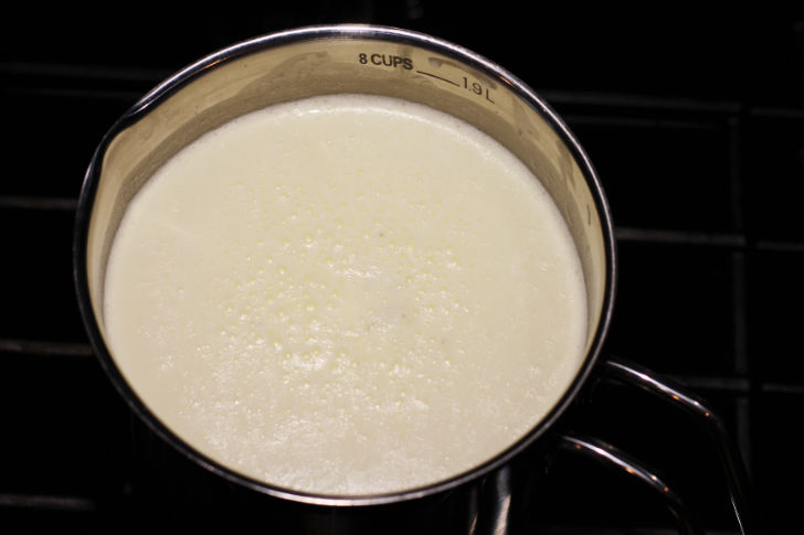 A pot is shown with 6 cups of scalded milk heated to 180°F until tiny bubbles form around the edges of the pan.