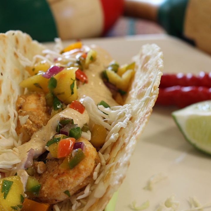 Shrimp Tacos with Mango Salsa on a plate with chilis and lime